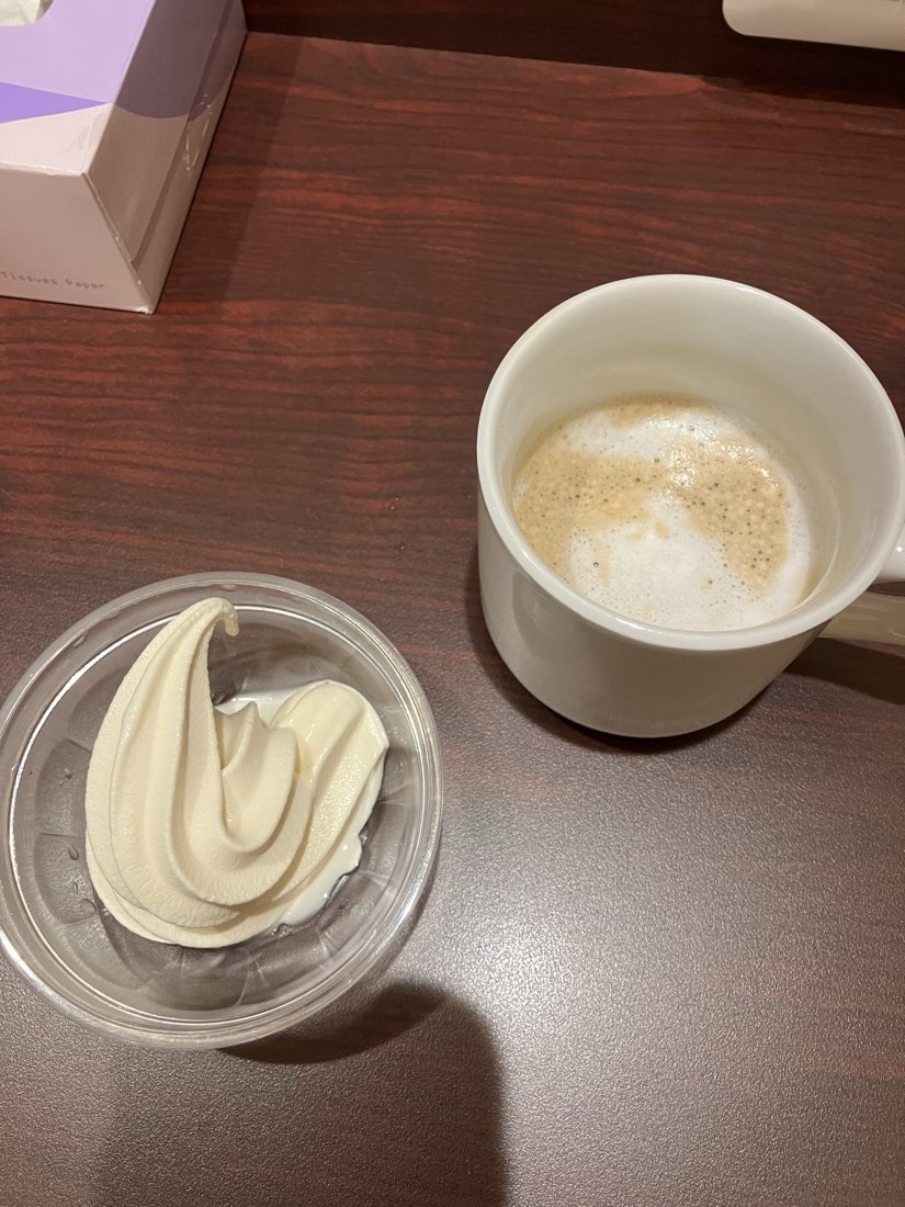 快活CLUBのソフトクリームとカフェラテ。木目のテーブルに並べたところ
